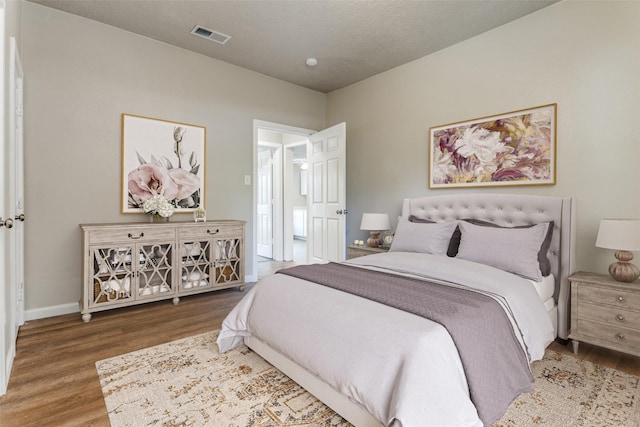 bedroom featuring a textured ceiling and hardwood / wood-style floors