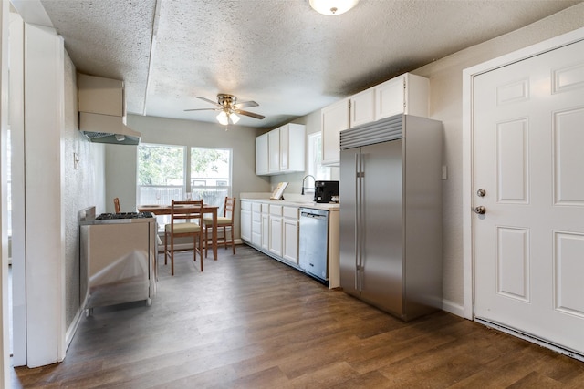 kitchen with a textured ceiling, white cabinetry, stainless steel appliances, dark hardwood / wood-style floors, and ceiling fan