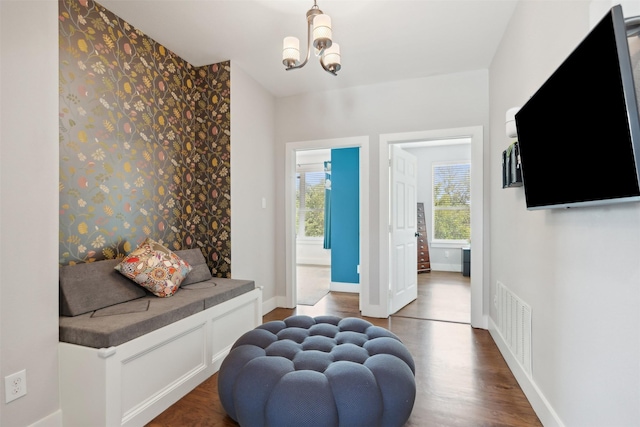 interior space with baseboards, visible vents, dark wood finished floors, and a notable chandelier