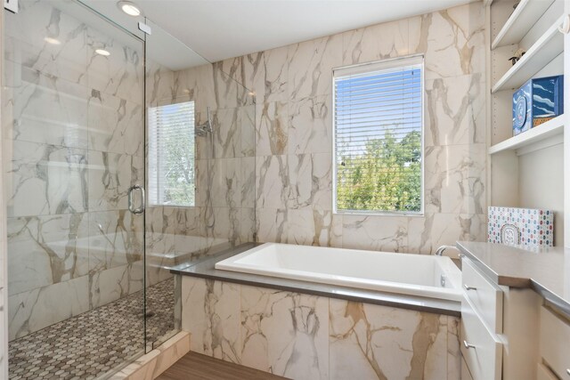 bathroom featuring tile walls and shower with separate bathtub