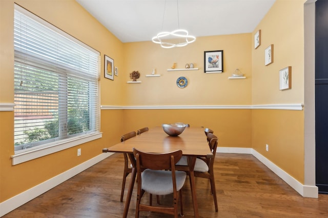 dining room featuring an inviting chandelier, baseboards, and wood finished floors