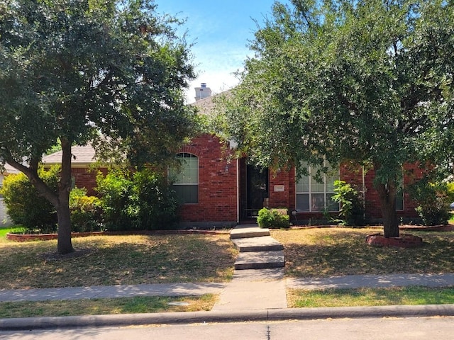 obstructed view of property featuring brick siding and a chimney