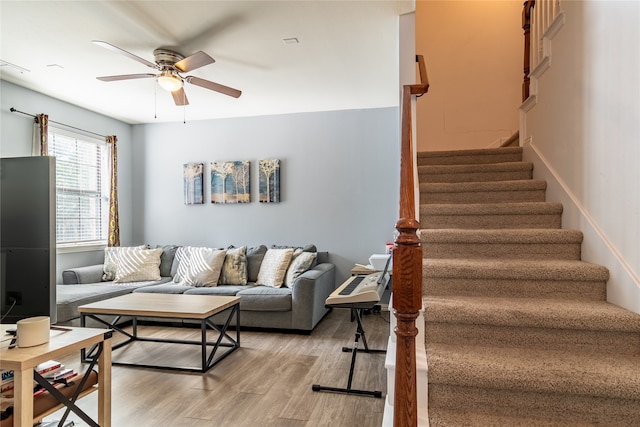 living room with light hardwood / wood-style flooring and ceiling fan