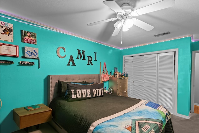 carpeted bedroom with ceiling fan and a closet