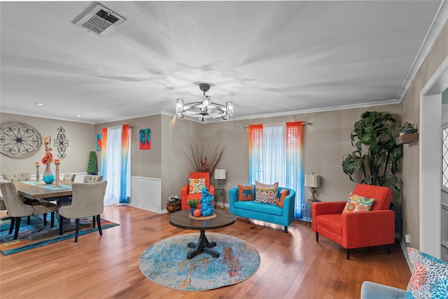 living room featuring hardwood / wood-style floors, a notable chandelier, and ornamental molding