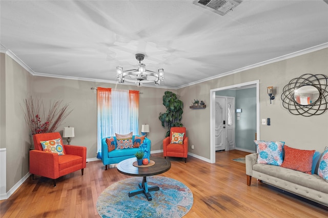 sitting room featuring ornamental molding, hardwood / wood-style floors, and a notable chandelier