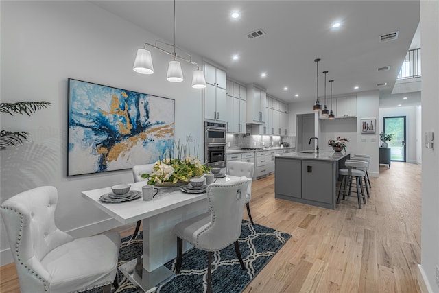 dining room featuring sink and light hardwood / wood-style floors