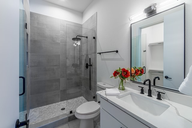 bathroom featuring vanity, toilet, and an enclosed shower