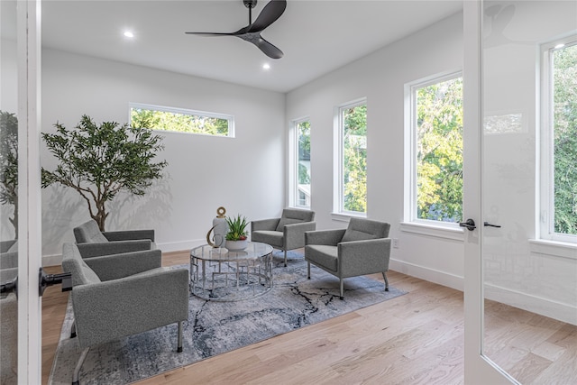 living room featuring ceiling fan, a wealth of natural light, and light wood-type flooring