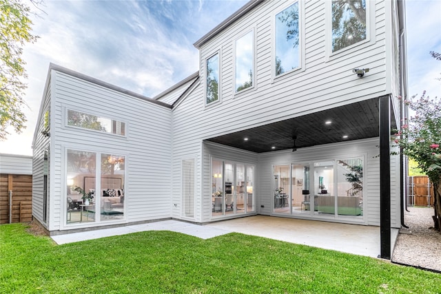 rear view of property featuring a yard, a patio area, and ceiling fan