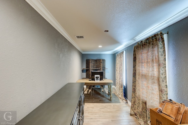 interior space featuring hardwood / wood-style floors, crown molding, and a textured ceiling