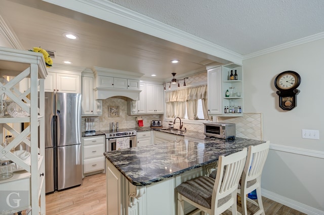 kitchen featuring a breakfast bar area, appliances with stainless steel finishes, light hardwood / wood-style floors, kitchen peninsula, and ornamental molding