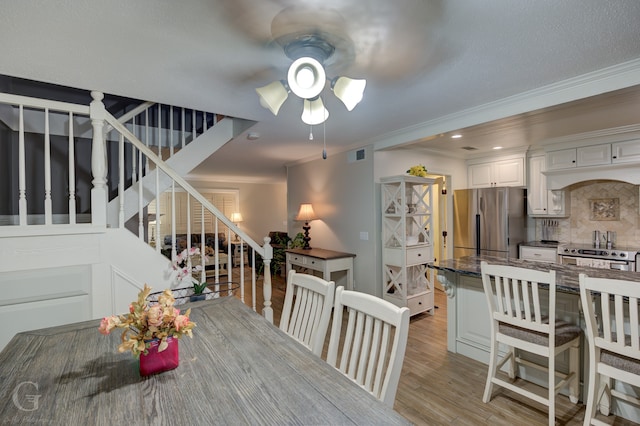 dining area featuring light hardwood / wood-style flooring, ceiling fan, and ornamental molding