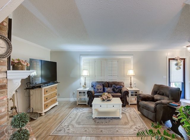 living room with a textured ceiling, light hardwood / wood-style flooring, ornamental molding, and a fireplace