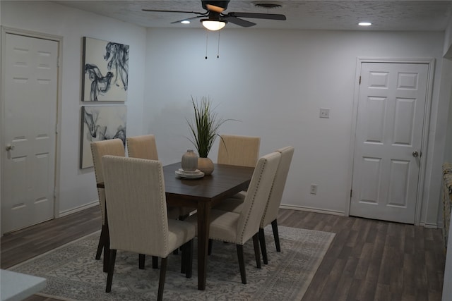 dining area with a textured ceiling, ceiling fan, and dark hardwood / wood-style flooring