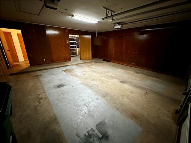 garage with a garage door opener and wooden walls