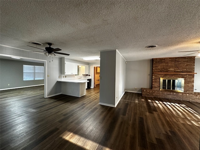 unfurnished living room with a textured ceiling, a fireplace, and dark wood-type flooring