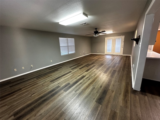 spare room featuring ceiling fan, dark hardwood / wood-style floors, french doors, and a textured ceiling