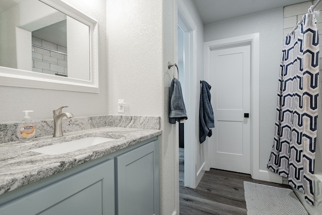 bathroom featuring walk in shower, vanity, and hardwood / wood-style flooring