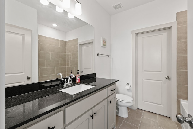 bathroom with vanity, a bathing tub, tile patterned flooring, and toilet