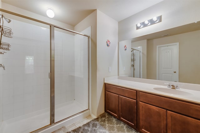 bathroom featuring tile patterned floors, vanity, and a shower with shower door