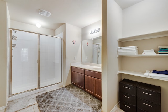 bathroom with vanity, tile patterned floors, and a shower with door