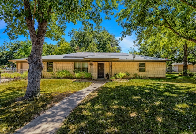 single story home with a front lawn and solar panels