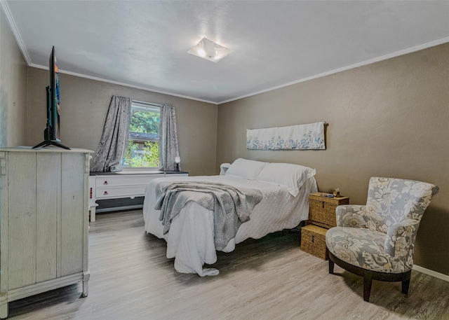 bedroom with ornamental molding and light hardwood / wood-style flooring