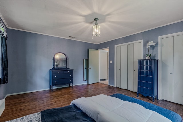 bedroom with crown molding, wood-type flooring, and multiple closets