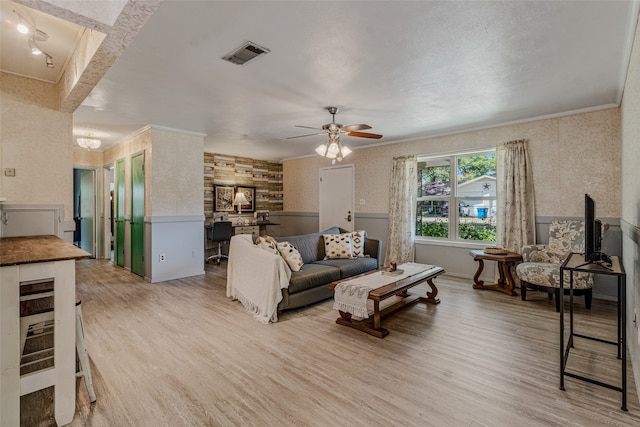 living room featuring crown molding, ceiling fan, and light hardwood / wood-style floors