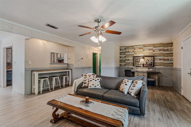 living room featuring crown molding, hardwood / wood-style flooring, and ceiling fan