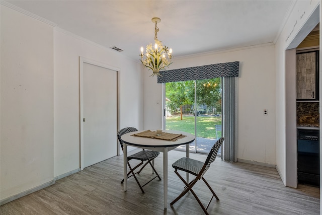 dining room with ornamental molding, hardwood / wood-style flooring, and a chandelier