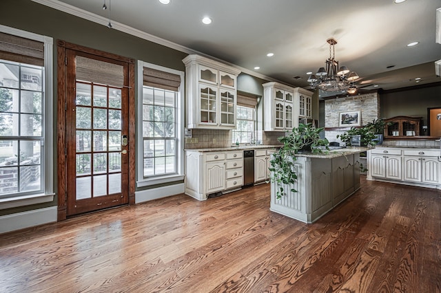 kitchen featuring decorative light fixtures, light stone countertops, white cabinetry, and a healthy amount of sunlight