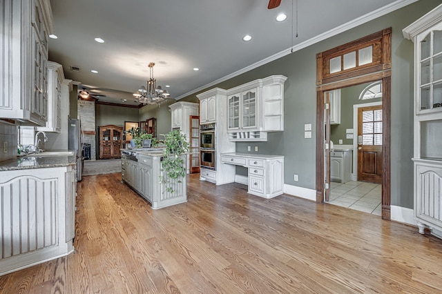 kitchen featuring a center island with sink, ceiling fan, white cabinets, and light hardwood / wood-style floors