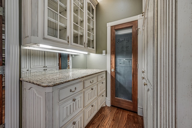 kitchen featuring dark wood-type flooring and light stone countertops