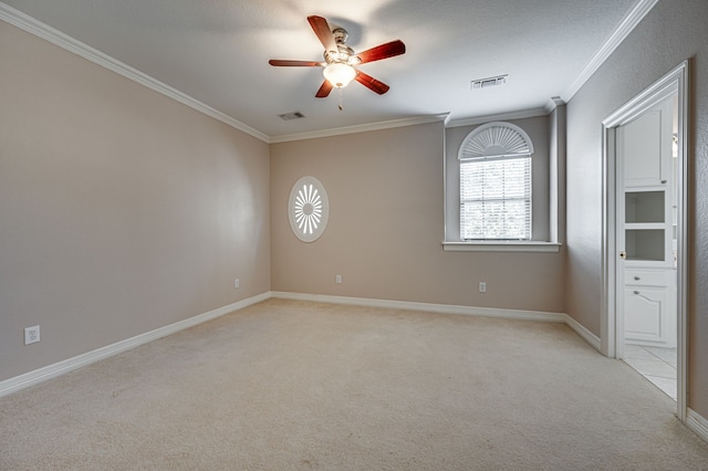 carpeted spare room featuring ceiling fan, a textured ceiling, and ornamental molding