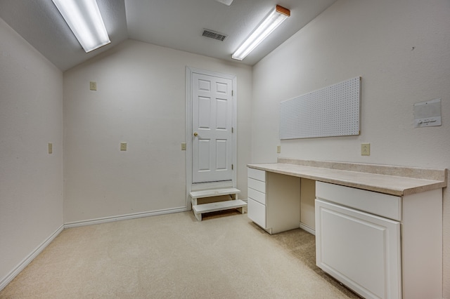 carpeted home office with lofted ceiling