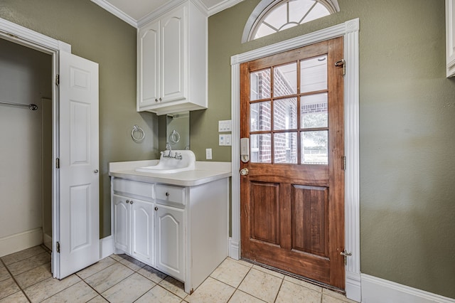 interior space with ornamental molding, light tile patterned floors, a healthy amount of sunlight, and sink