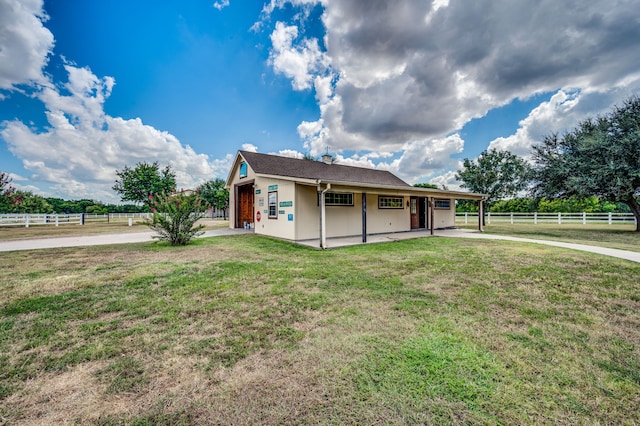 rear view of house with a yard and a rural view