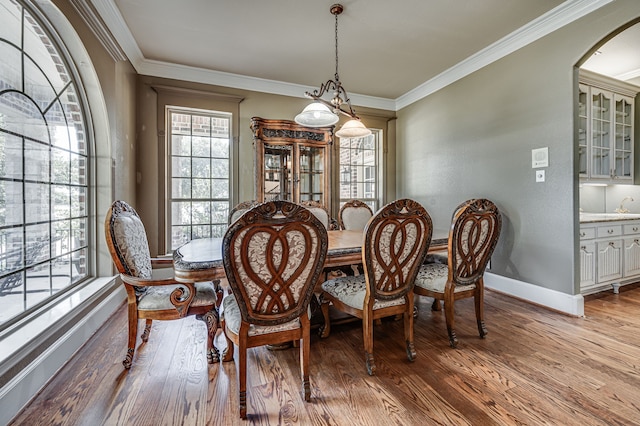 dining area with ornamental molding and light wood-type flooring