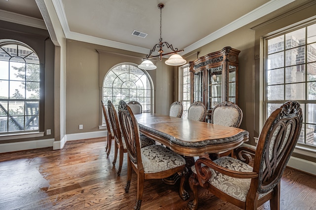 dining area featuring ornamental molding, an inviting chandelier, and dark hardwood / wood-style floors