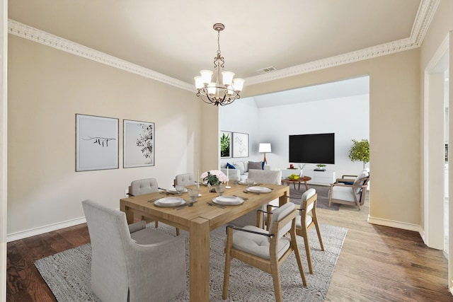 dining area featuring hardwood / wood-style flooring, an inviting chandelier, and ornamental molding