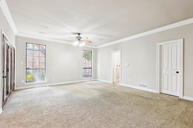 carpeted empty room featuring ceiling fan, ornamental molding, and a healthy amount of sunlight