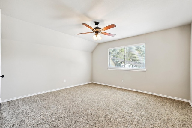 carpeted spare room featuring lofted ceiling and ceiling fan