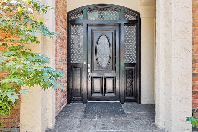 doorway to property featuring brick siding