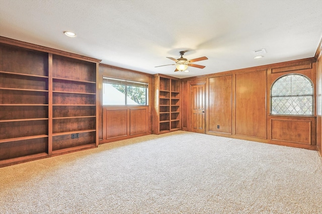 carpeted empty room featuring ceiling fan and a textured ceiling