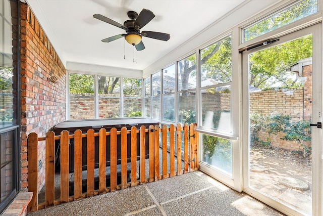 unfurnished sunroom featuring ceiling fan