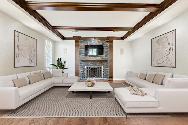 living room with hardwood / wood-style floors, beam ceiling, and a fireplace