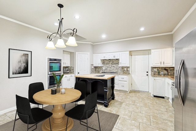 kitchen with white cabinets, decorative backsplash, stainless steel appliances, and a chandelier