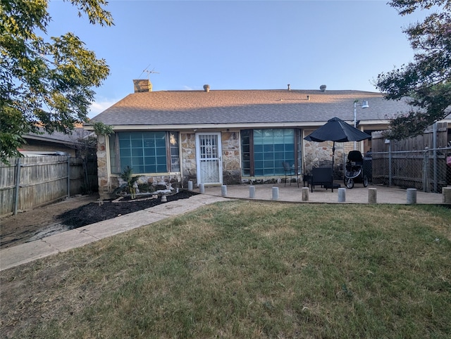 rear view of house featuring a patio area and a lawn